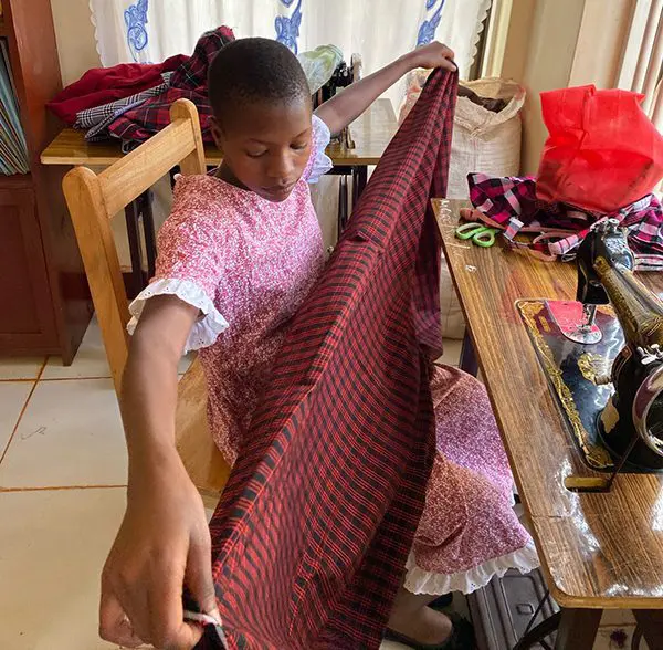 Sayuni measuring fabric before stitching