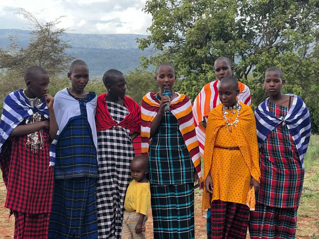 Momoi (center holding microphone) was able to use her language skills to translate her friends' testimonies at the Community Celebration. She speaks Maa, Swahili and English.