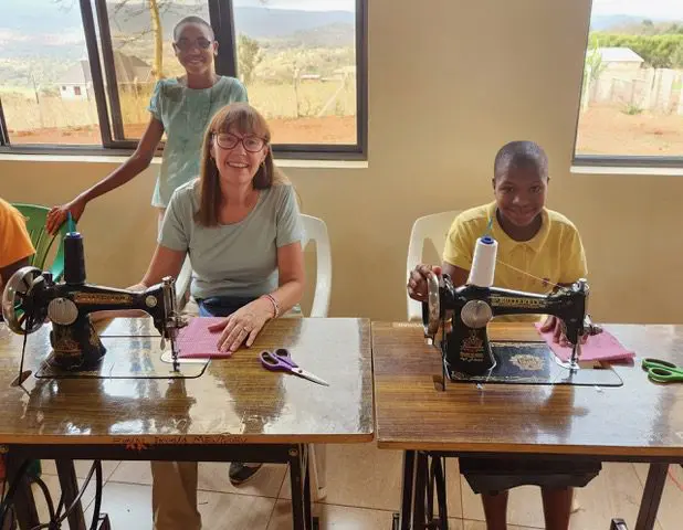 Volunteer in Tanzania sitting behind a sewing machine
