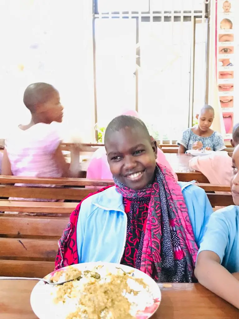 Neema smiling at the lunch table