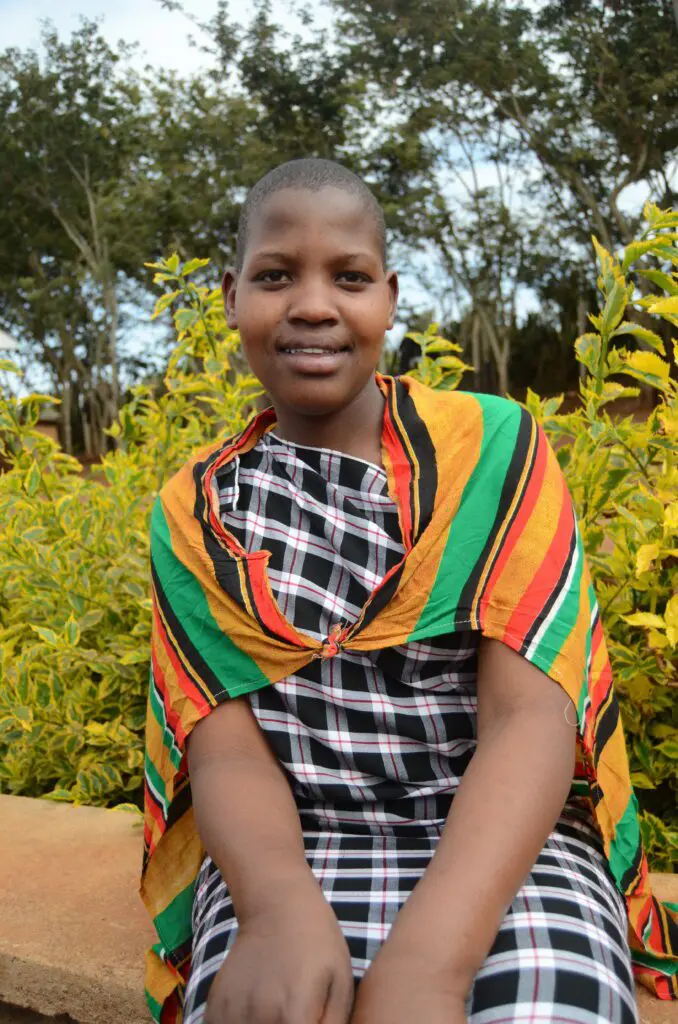 portrait of Yeyolai sitting outside in traditional Maasai apparel