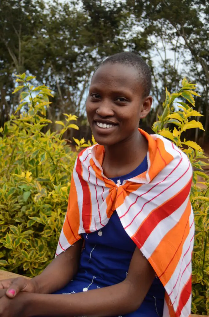 portrait of Nemoipo sitting outside in traditional Maasai apparel