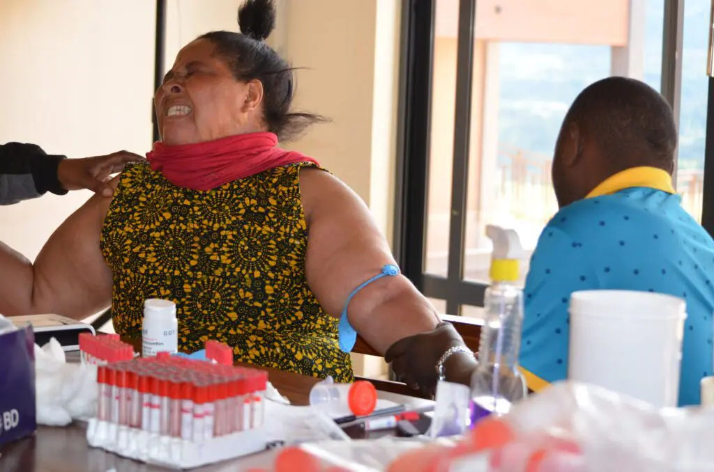 One of our house mothers grimacing whille receiving her immunization shots given by the medical doctor