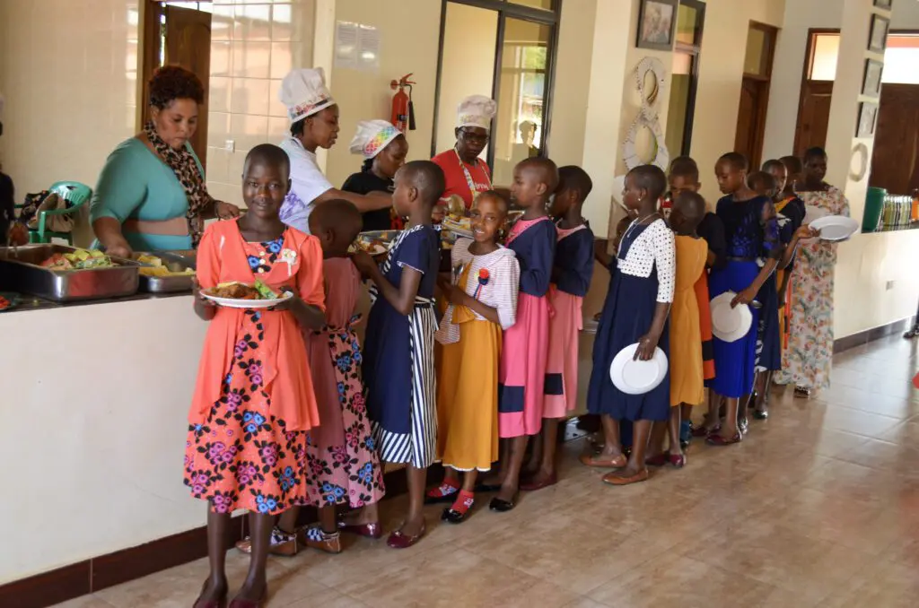 Maasai girls in line being served  nutritious foods. 