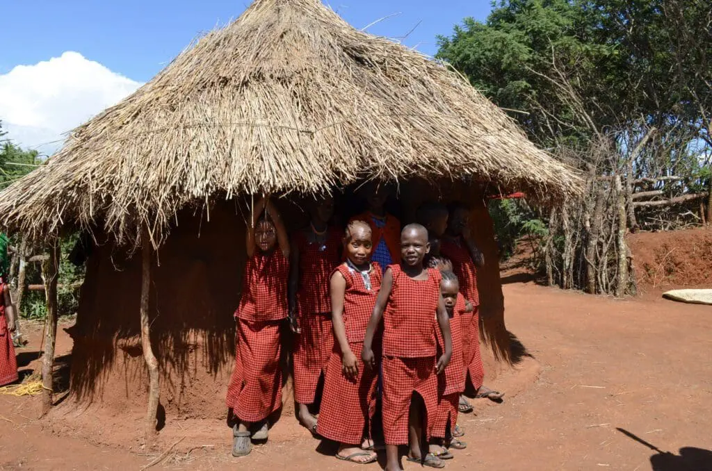 young maasai girls standing in front of a boma