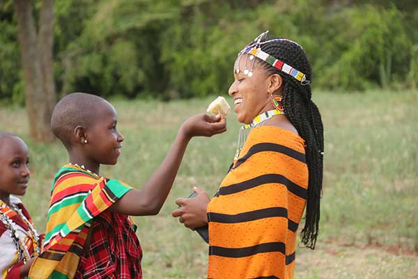 Namanyani Philipo participates in Tanzanian tradition by feeding cake to MGRC house mother, Penlie.