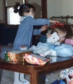 young girl braiding her sisters hair