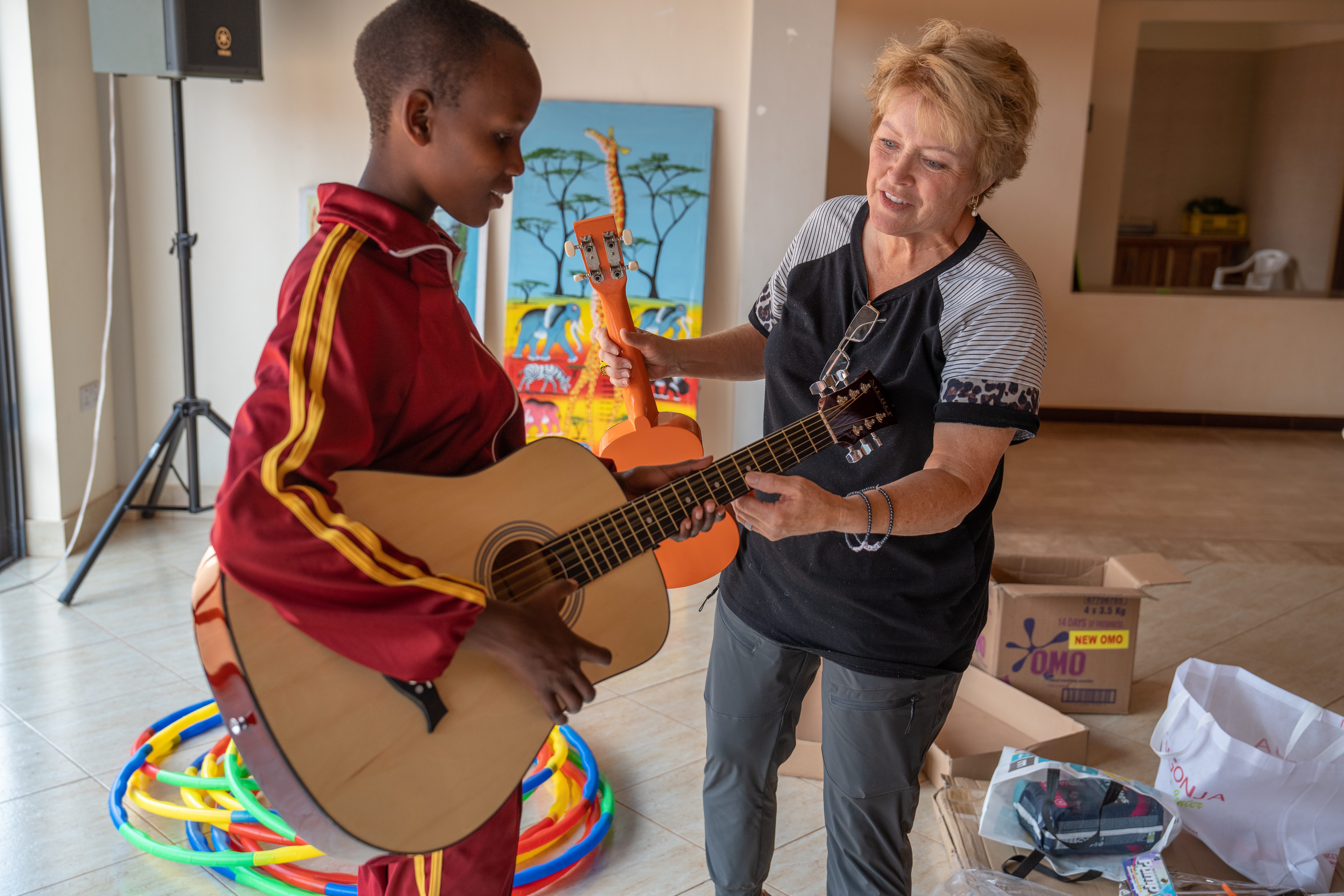 a sponsor teaching a girl to play guitar