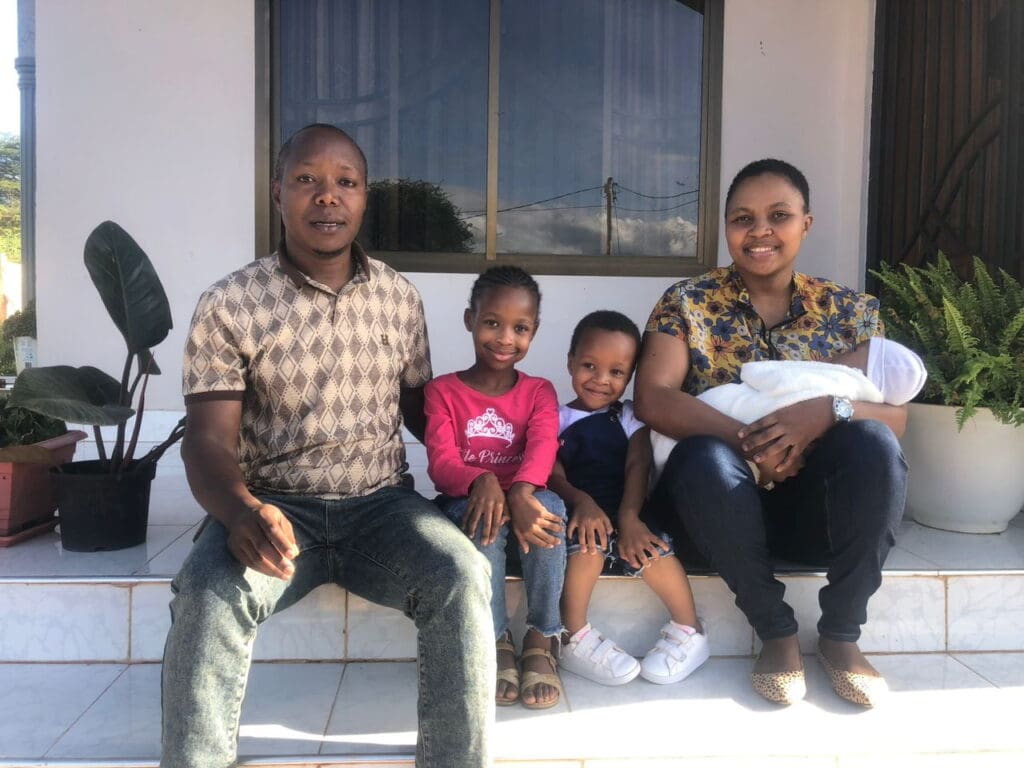 man sitting with his family outside on their home