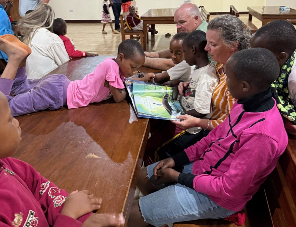 MGRC sponsor reading a book to young maasai girls was a life altering experience in africa