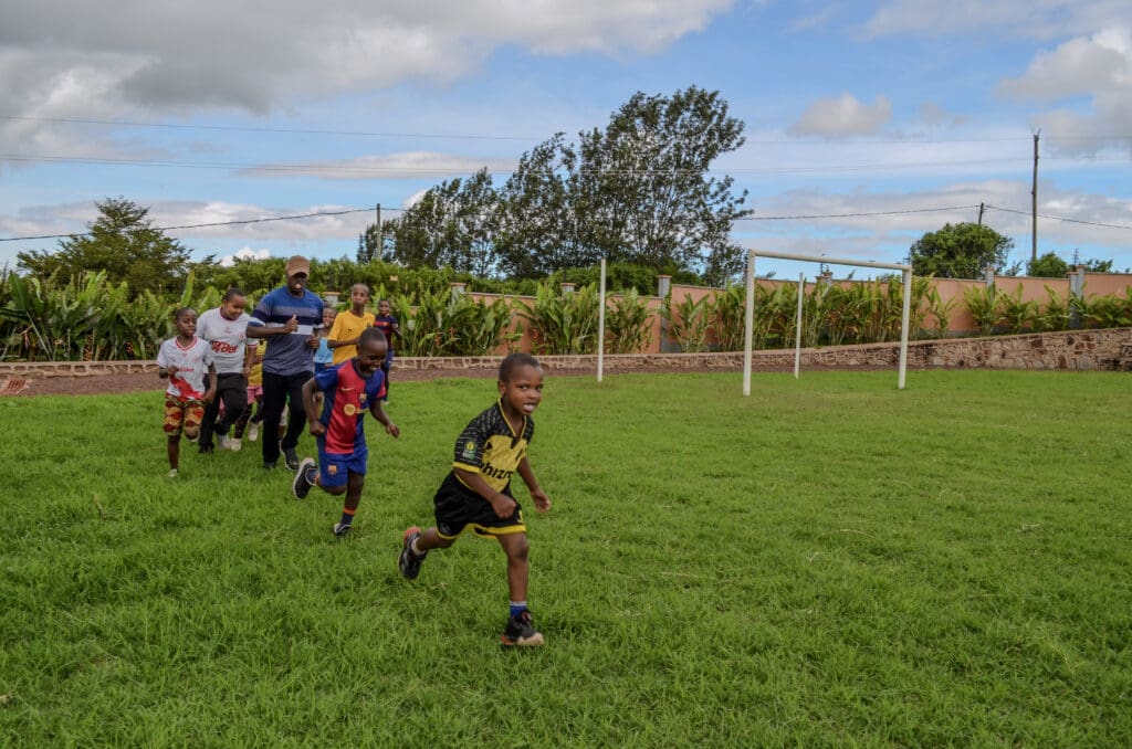 Children running on a grassy field as part of the track competition held at MGRC.