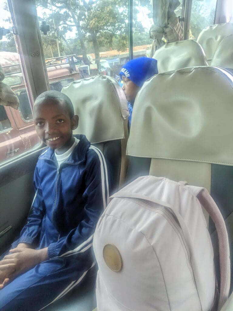 Young maasai girl sitting on our bus preparing for a trip.