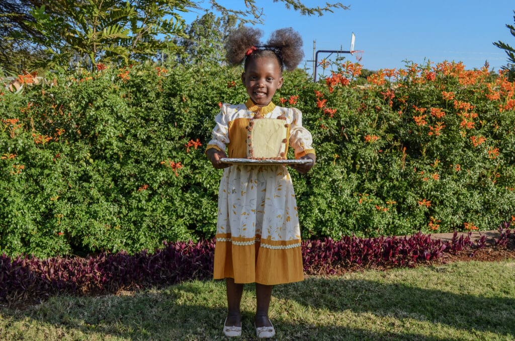 girl holding a birthday cake. monthly birthdays are celebrated at MGRC. 